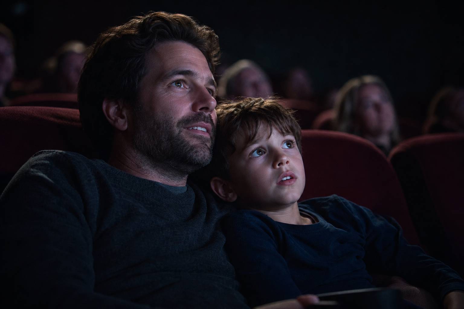 Parent et enfant assis au cinéma regardant le film émotion partagée